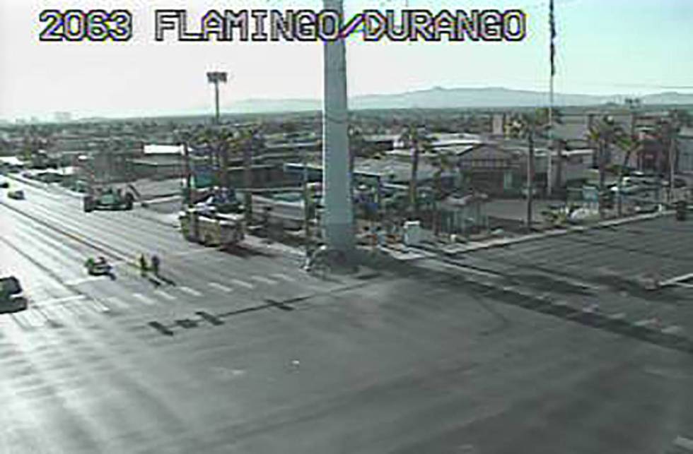 Las Vegas police inspect a vehicle that crashed into the base of a power transmission line pole ...