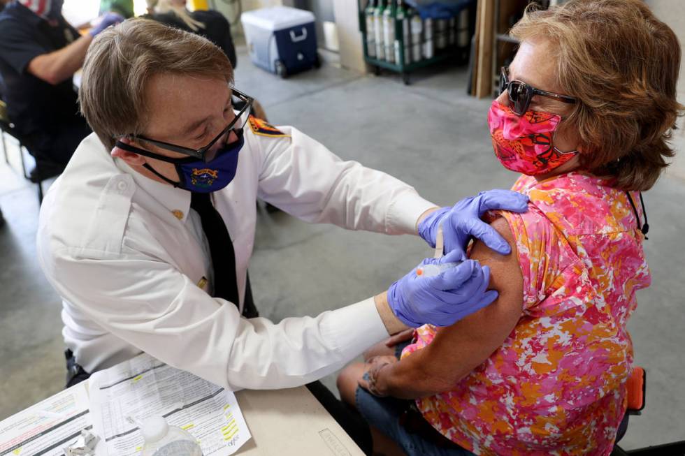 Clark County Fire Department Chief John Steinbeck gives a COVID-19 vaccine to Lynn Mendez, 58, ...