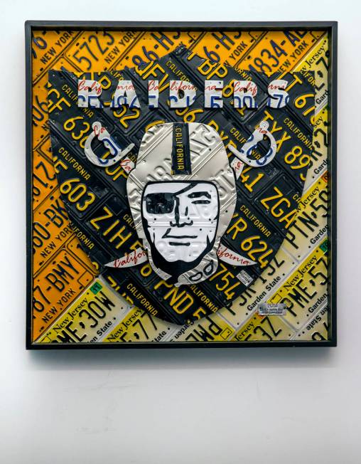 A Raiders logo art piece constructed of license plates hangs in a hallway during a tour of the ...