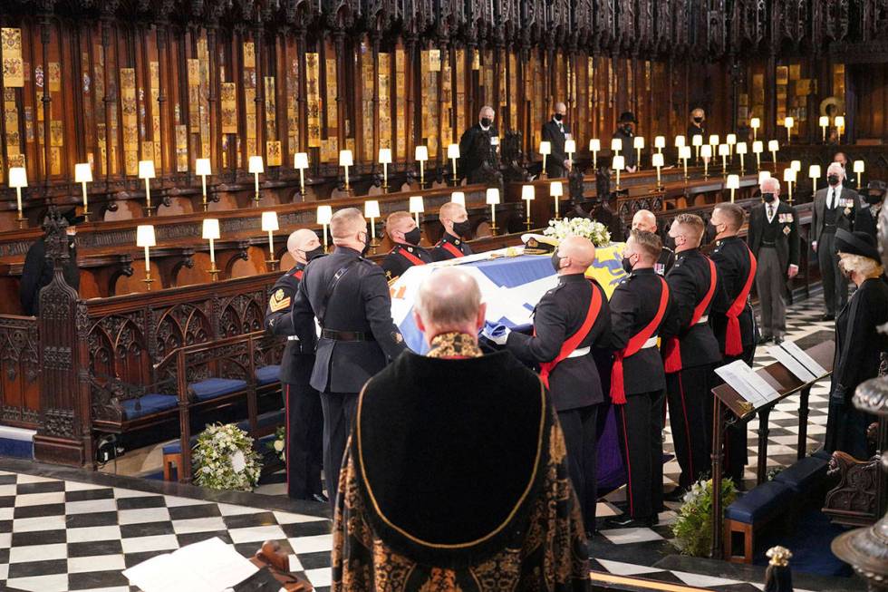 Britain's Queen Elizabeth II, obscured left, looks on the flag draped coffin in St. George&#x20 ...