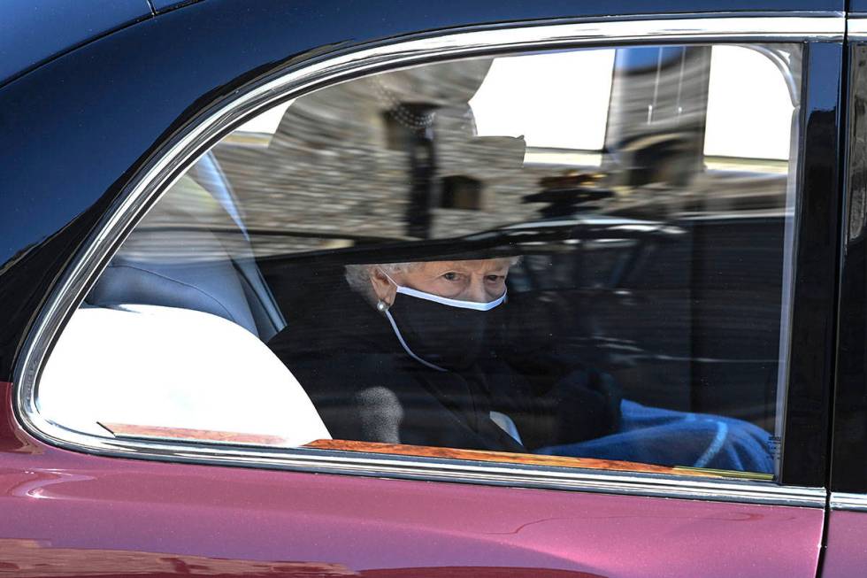 Britain's Queen Elizabeth II follows the coffin in a car as it makes it's way past the Round To ...