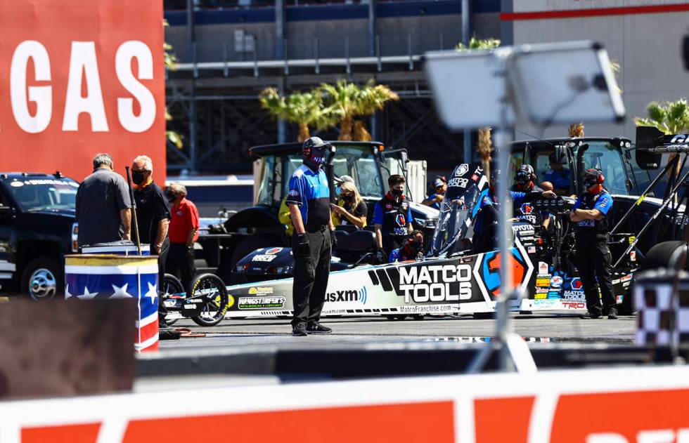 Crew members for Antron Brown help prepare for the final round of Top Fuel at the Denso Spark P ...