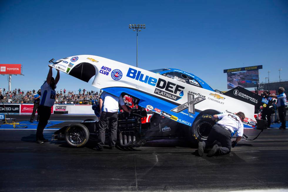 Crew members for John Force make adjustments for second elimination round of Funny Car at the D ...