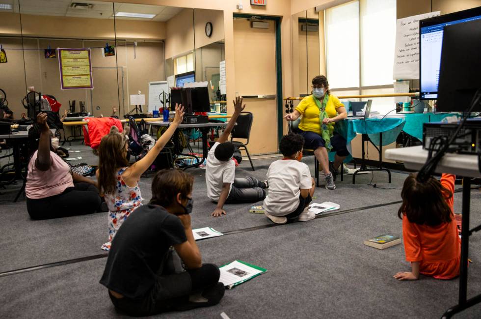 Students raise their hands as learning guide Tammy Slank, right, leads a discussion during a th ...