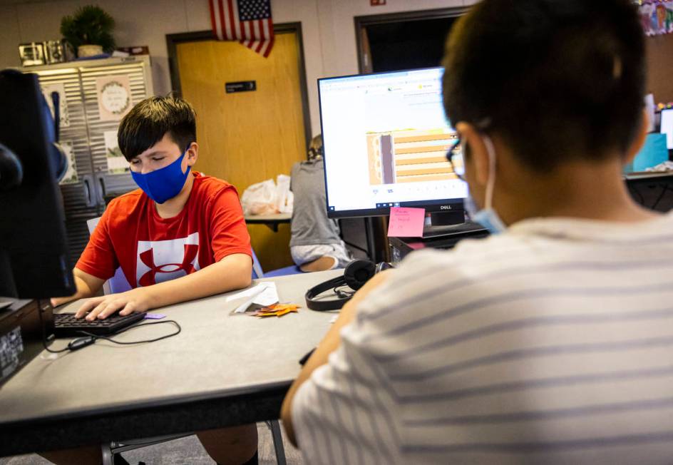 Fifth-graders Michael Bean, left, and Aaron Falcon, both 11, work on math studies during a clas ...