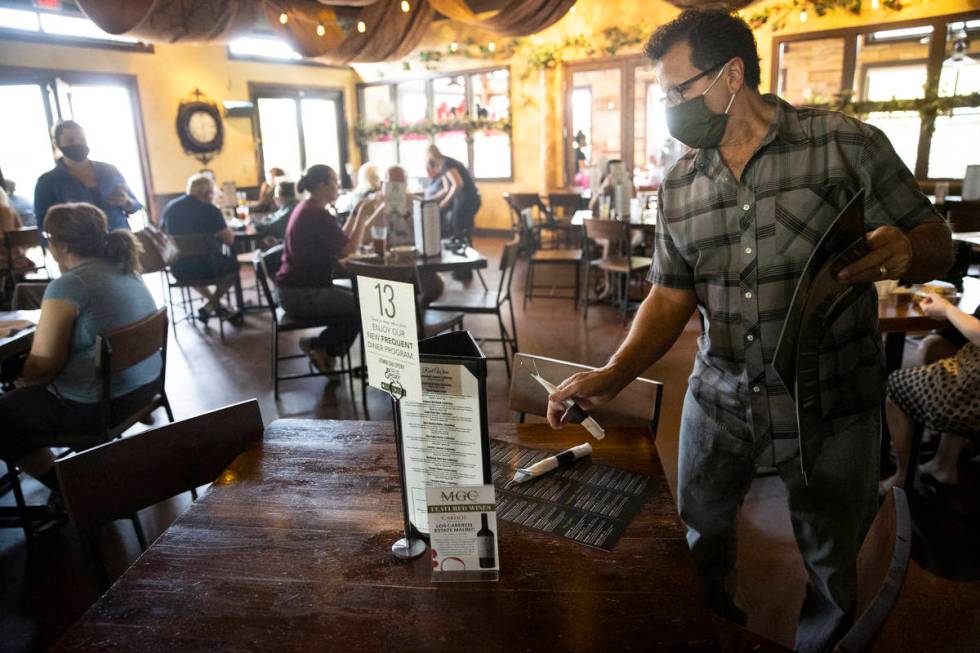 Joe Pierro, owner of Market Grille Cafe, sets up a table for customers. Labor shortages are req ...