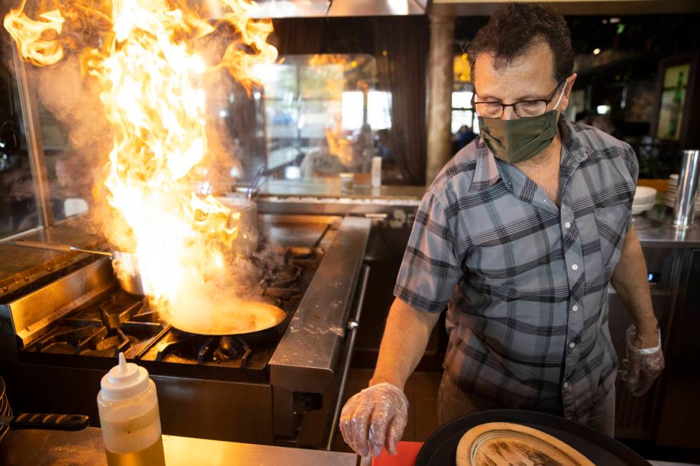 Joe Pierro, owner of Market Grille Cafe, prepares Saganaki, melted cheese, at his N. Durango Dr ...