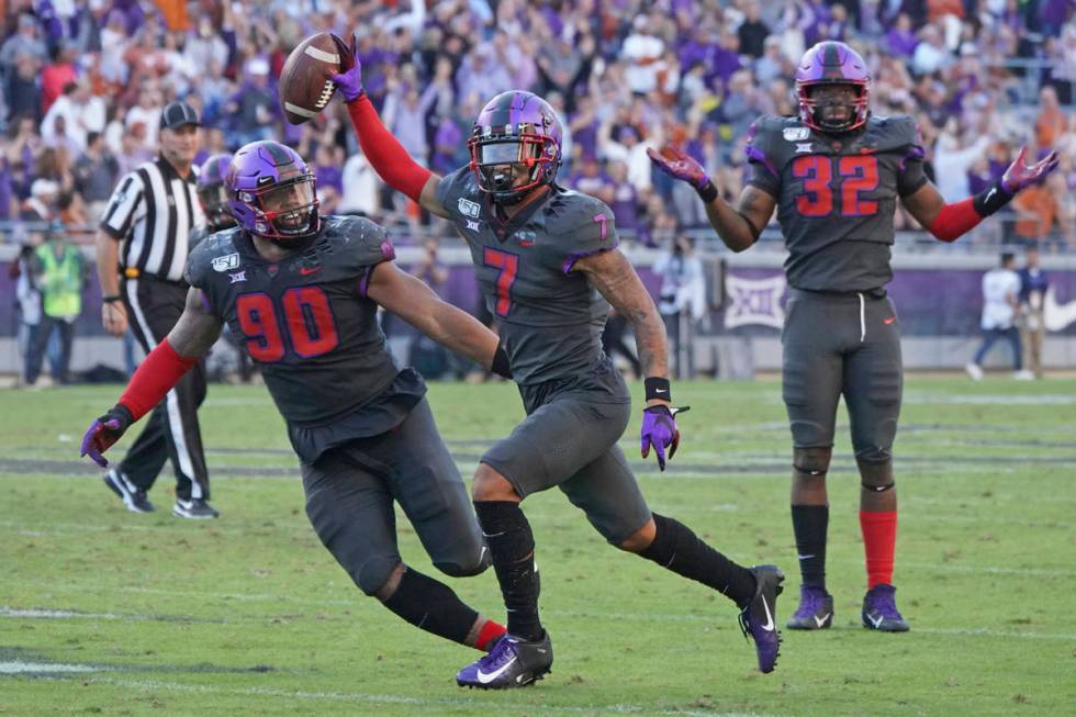 TCU safety Trevon Moehrig (7) celebrates his interception with teammates Ross Blacklock (90) an ...