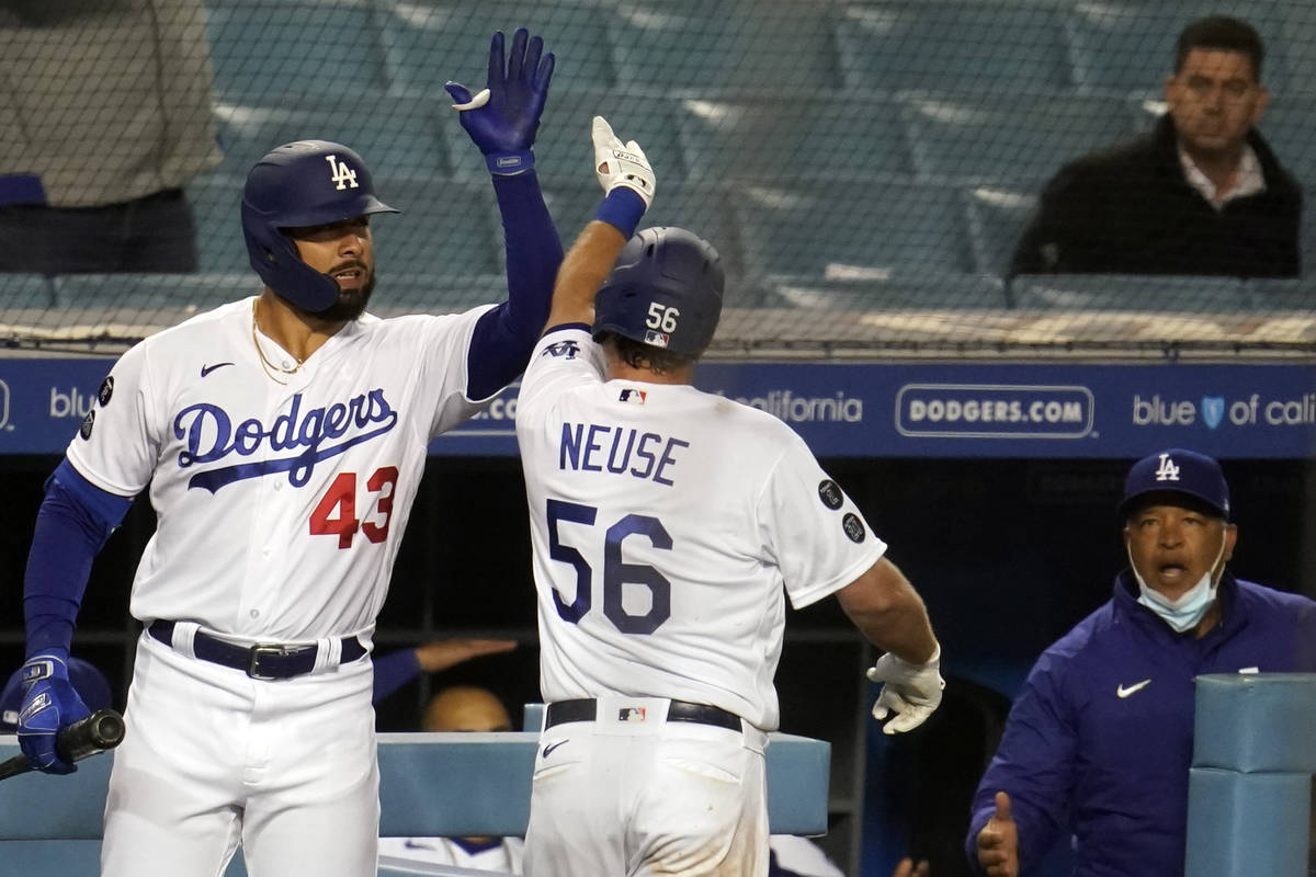 Los Angeles Dodgers' Sheldon Neuse (56) celebrates his solo home run with Edwin Rios (43) durin ...