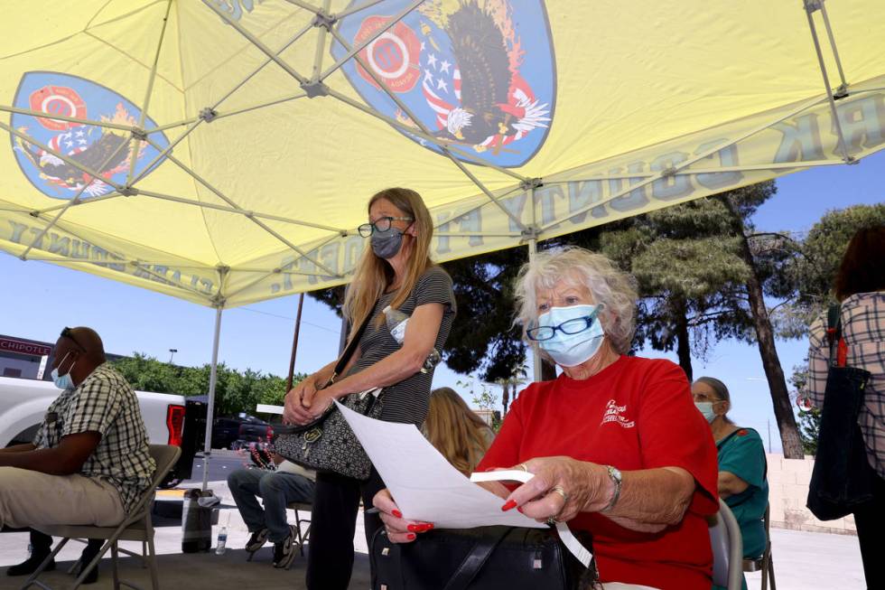 Phyllis Byre, right, and Lori Brown, 59, both of Las Vegas wait for a COVID-19 vaccine during a ...