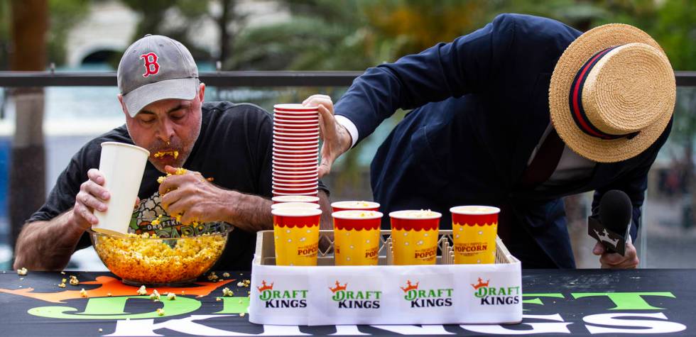 Geoff Esper, left, competes in the World Popcorn Eating Championship as emcee George Shea, righ ...