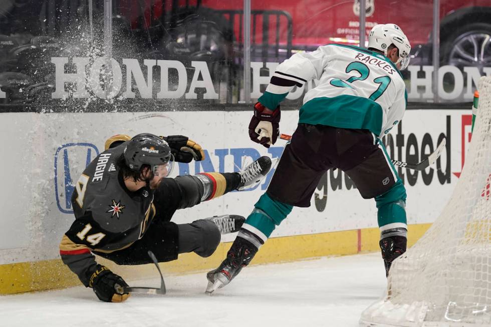 Vegas Golden Knights' Nicolas Hague, left, falls to the ice while fighting for the puck with An ...