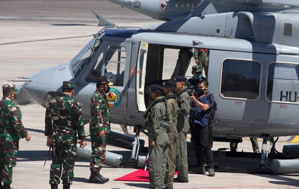 Indonesian Military chief Hadi Tjahjanto, third from left, boards a helicopter for a search mis ...