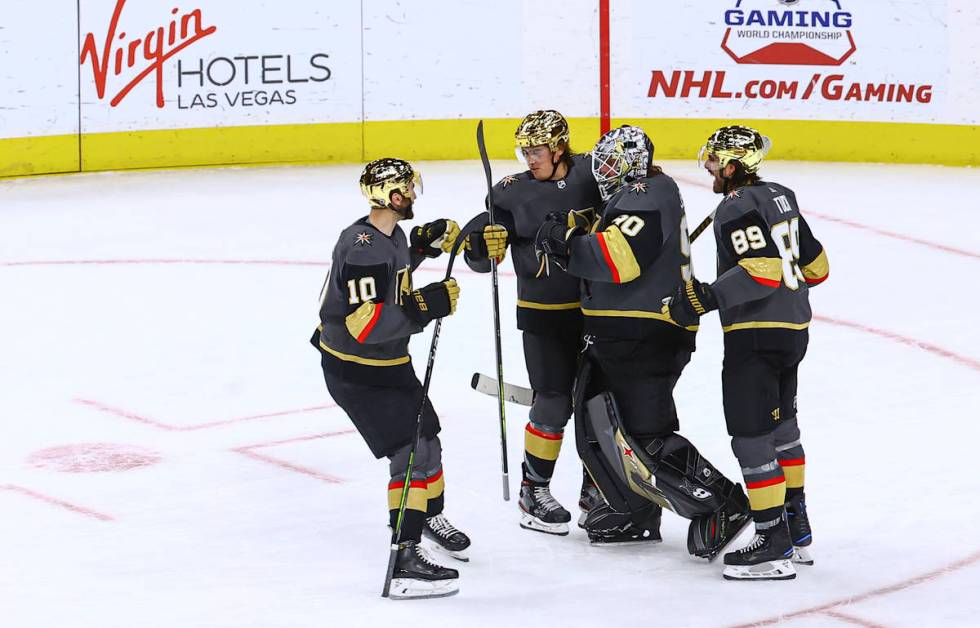 Golden Knights players celebrate with goaltender Robin Lehner after a shootout win against the ...