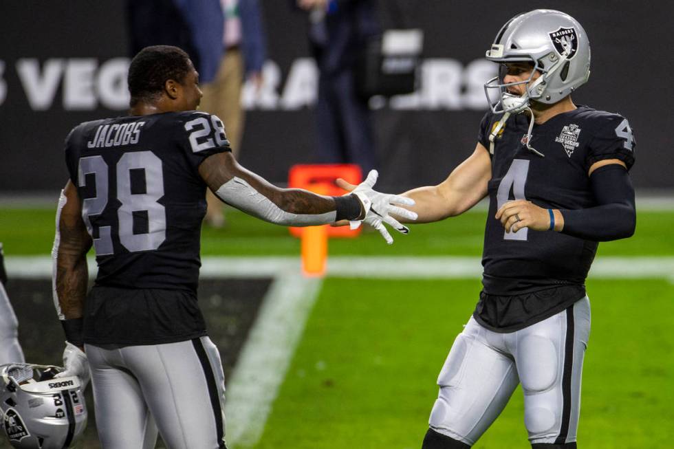 Las Vegas Raiders running back Josh Jacobs (28, left) greets quarterback Derek Carr (4) during ...