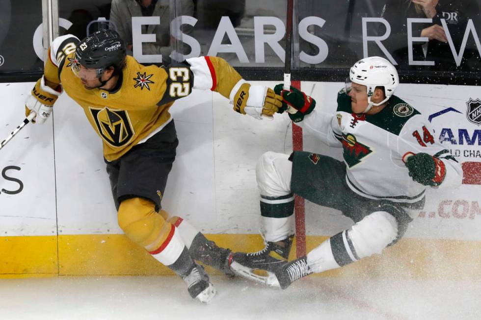 Vegas Golden Knights defenseman Alec Martinez (23) tangles with Minnesota Wild center Joel Erik ...