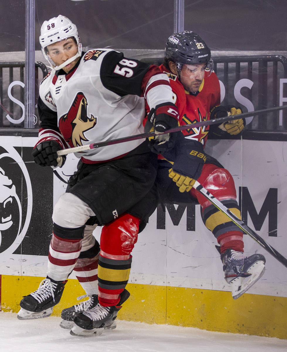 Arizona Coyotes left wing Michael Bunting (58) battles with Golden Knights defenseman Alec Mart ...