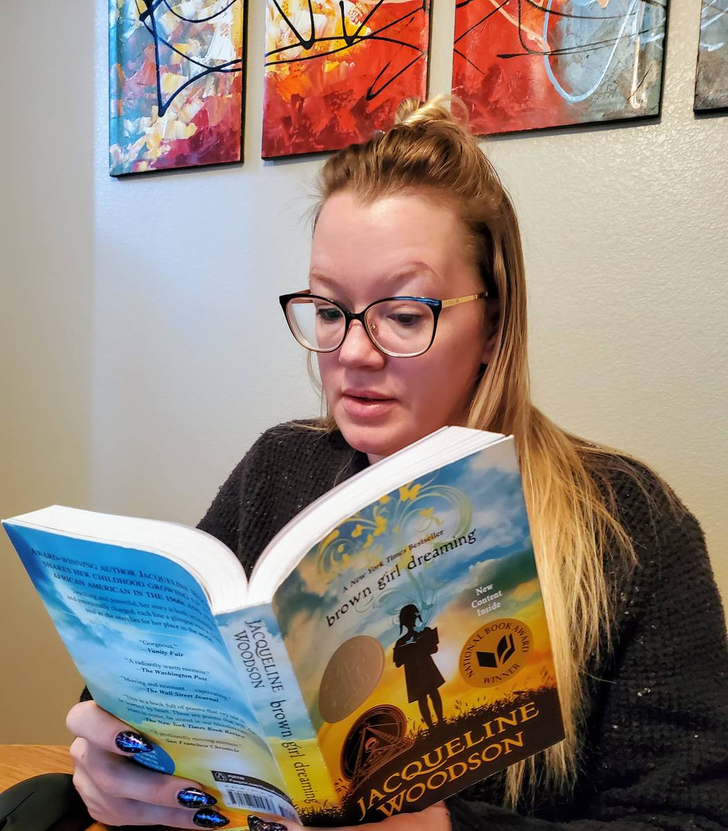 Ashley Price, a teacher at Monaco Middle School in Las Vegas, reads one of the books she reques ...