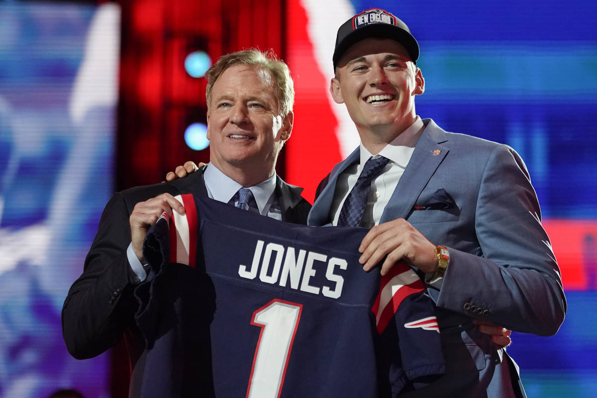 Alabama quarterback Mac Jones, right, holds a team jersey with NFL Commissioner Roger Goodell a ...