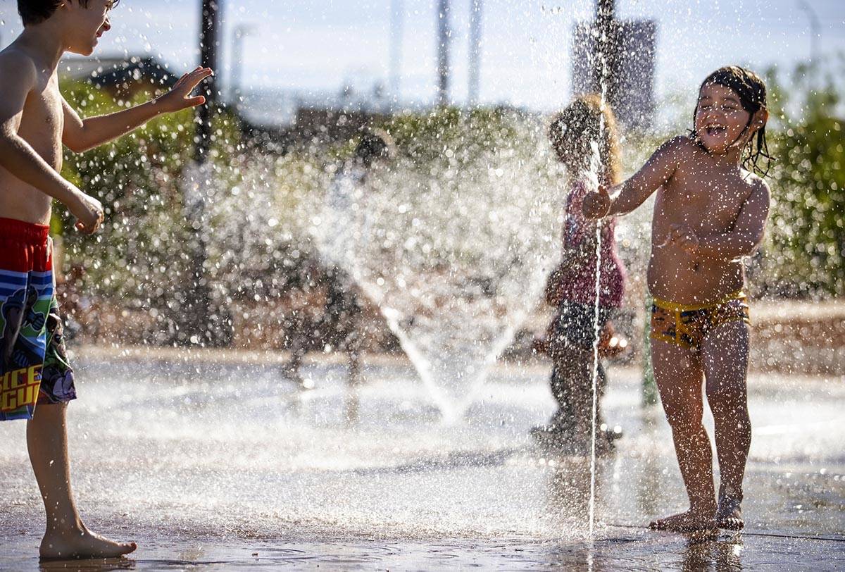 Bodhi Brown, 5, right, punches at the water as Charlie Oliphant, 7, moves in while playing in t ...