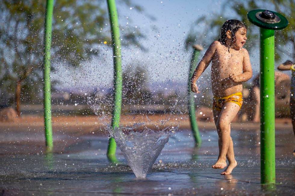 Bodhi Brown, 5, is sprayed from a fountain while playing in the water park at Bill Briare Famil ...