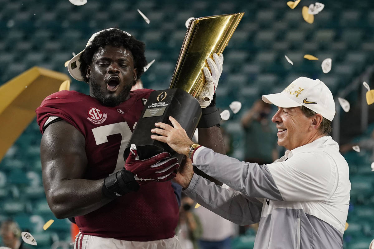 Alabama head coach Nick Saban and offensive lineman Alex Leatherwood hold the trophy after thei ...