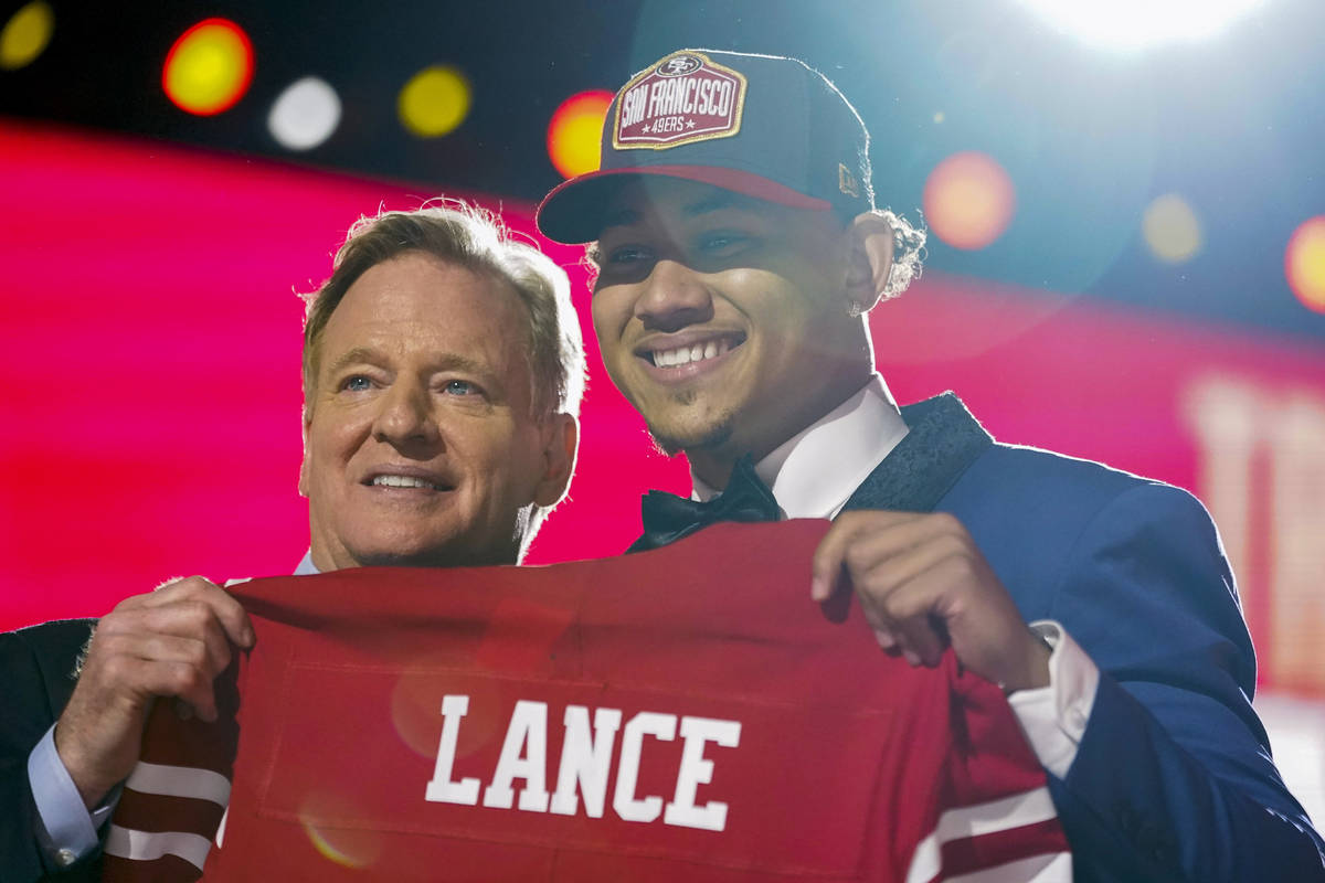 North Dakota State quarterback Trey Lance, right, holds a jersey with NFL Commissioner Roger Go ...