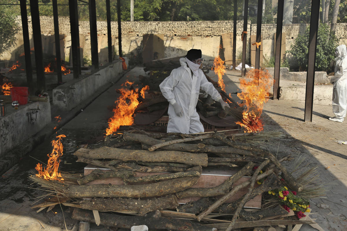 A family member performs the last rites of a COVID-19 victim at a crematorium in Jammu, in Jamm ...