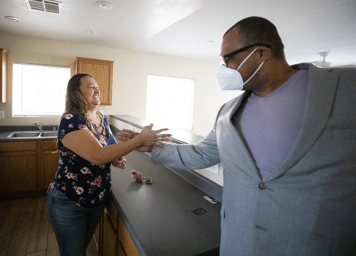 First-time homebuyer Amy Phinsee, left, fist bumps and shakes hands with realtor Cassidy Cotten ...