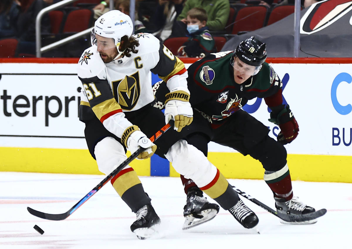 Golden Knights' Mark Stone (61) skates with the puck under pressure from Arizona Coyotes' Chris ...
