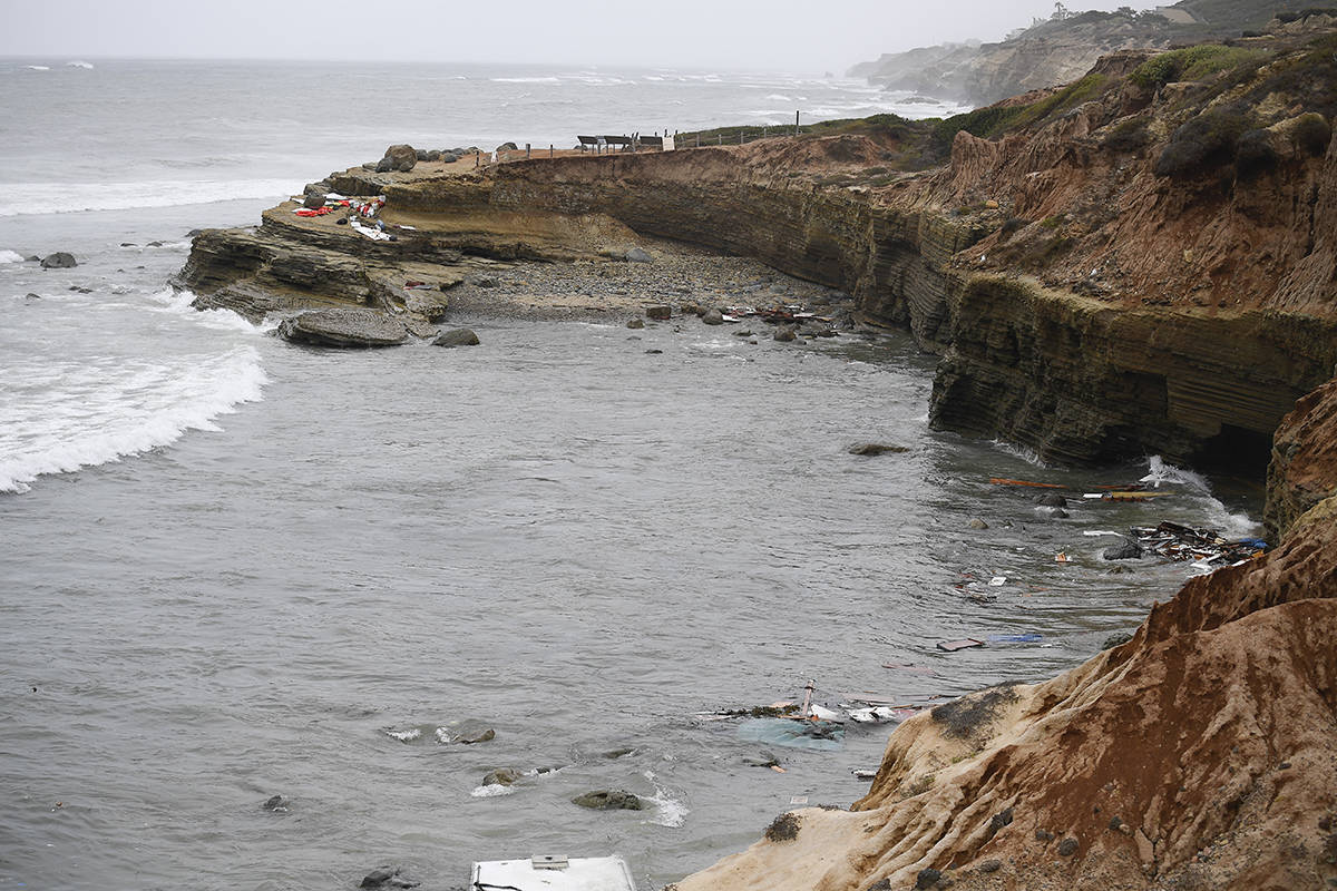 Wreckage and debris from a capsized boat washes ashore at Cabrillo National Monument near where ...
