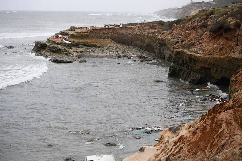 Wreckage and debris from a capsized boat washes ashore at Cabrillo National Monument near where ...