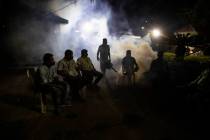 A municipal worker fumigates as supporters of Bharatiya Janata Party wait outside a vote counti ...