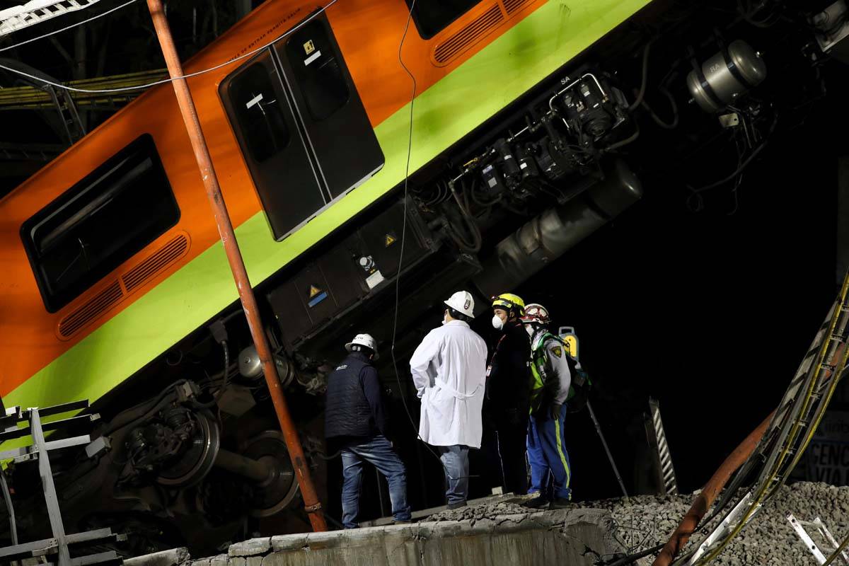 Personnel work in the rescue efforts after subway cars fell when a section of Line 12 of the su ...