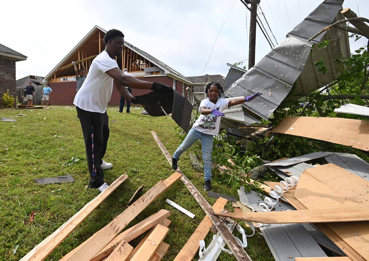 Derrick Pounds and his daughter, Madison, 6, clean up debris around their residence on Elvis Pr ...