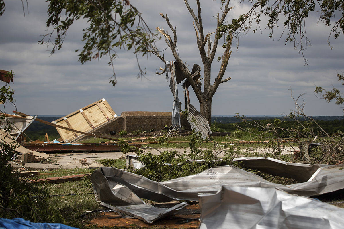 Metal parts of roof are tangled in a tree after a tornado near the storm shelter at the Barn on ...