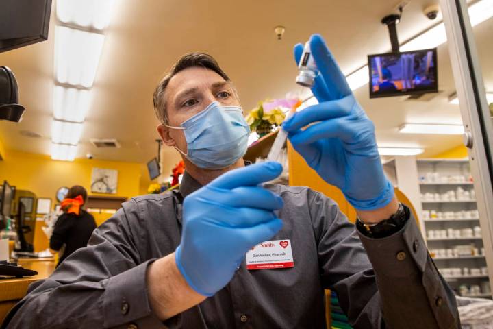 Dan Heller as the Health & Wellness Pharmacy Practice Coordinator draws up a syringe of the Mod ...