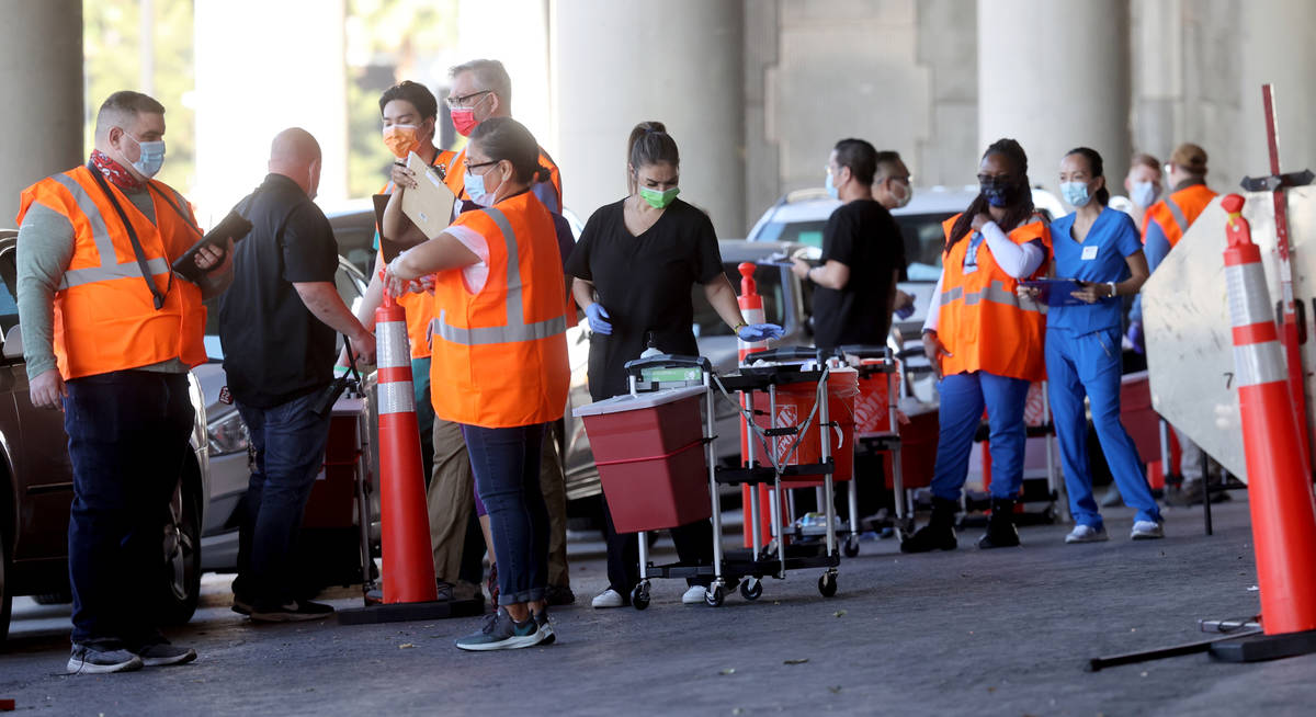 Workers prepare during a drive-thru COVID-19 vaccine clinic in the Bronze Lot at the Las Vegas ...