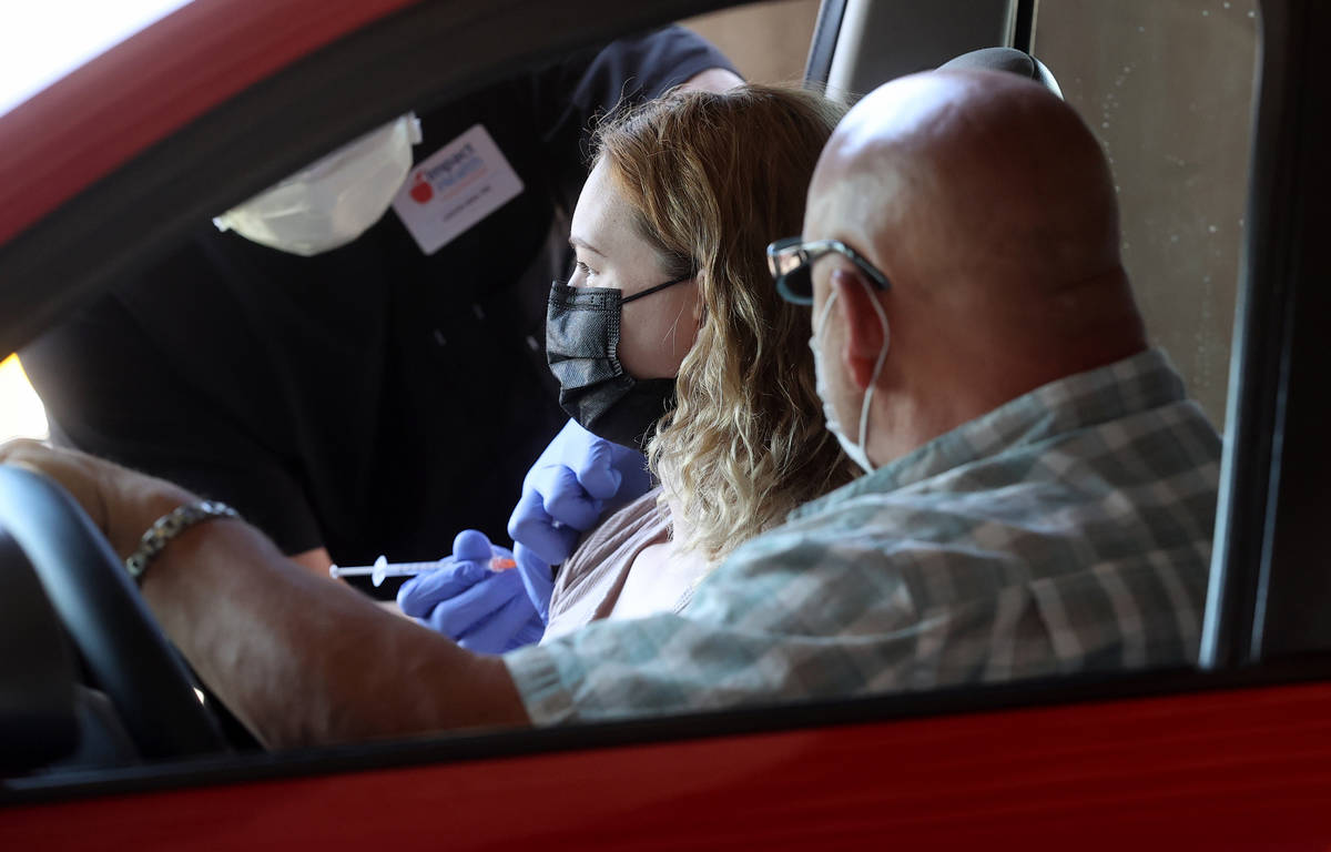 Cydney Rocheleau of Pahrump gets her shot as her father Peter Zurzolo looks on during a drive-t ...