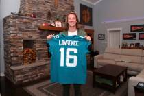 Clemson quarterback Trevor Lawrence holds up a jersey after being selected by the Jacksonville ...