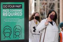 A sign requiring face masks is seen at City Creek Center in Salt Lake City in March 2021. (AP P ...