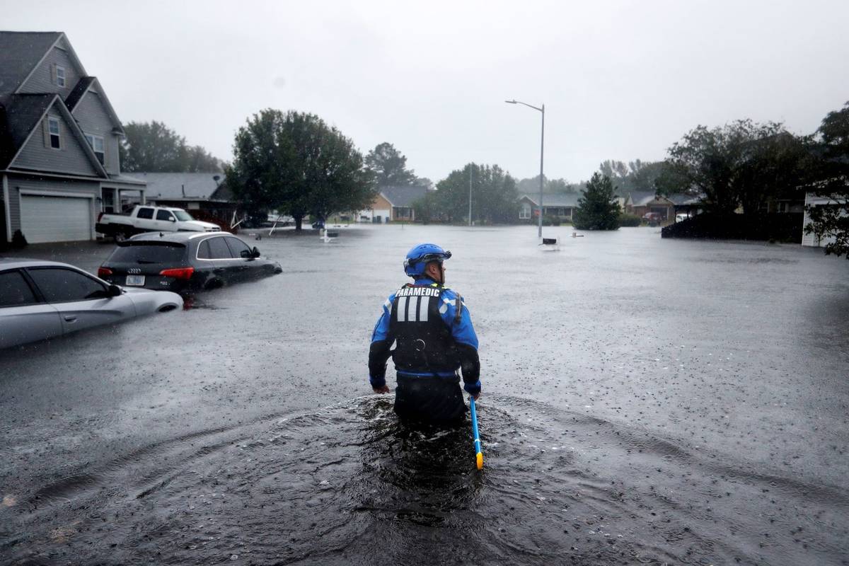 A member of the North Carolina Task Force urban search and rescue team wades through a flooded ...
