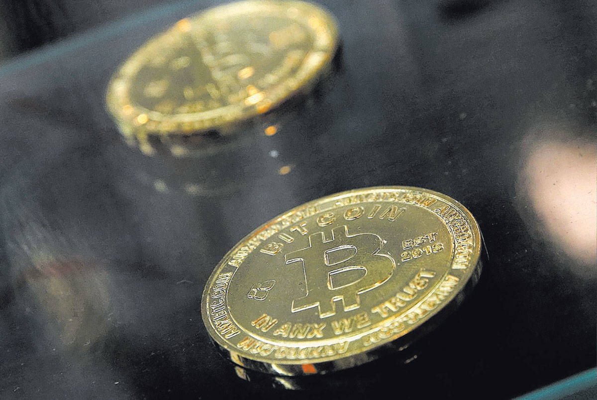 Coins are displayed next to a Bitcoin ATM in Hong Kong. (AP Photo/Kin Cheung)