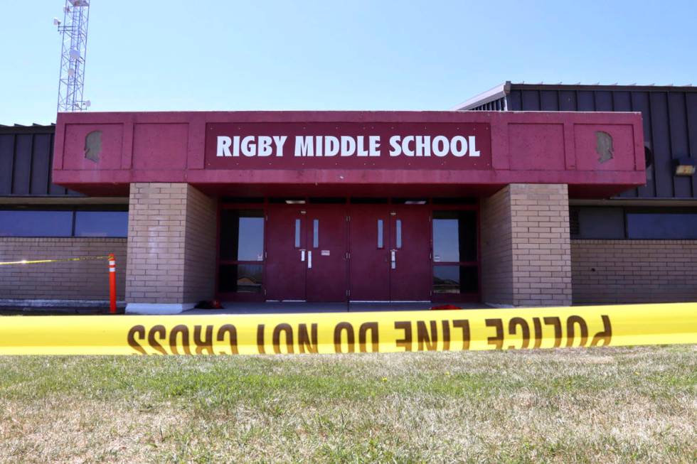 Police tape marks a line outside Rigby Middle School following a shooting there earlier Thursda ...