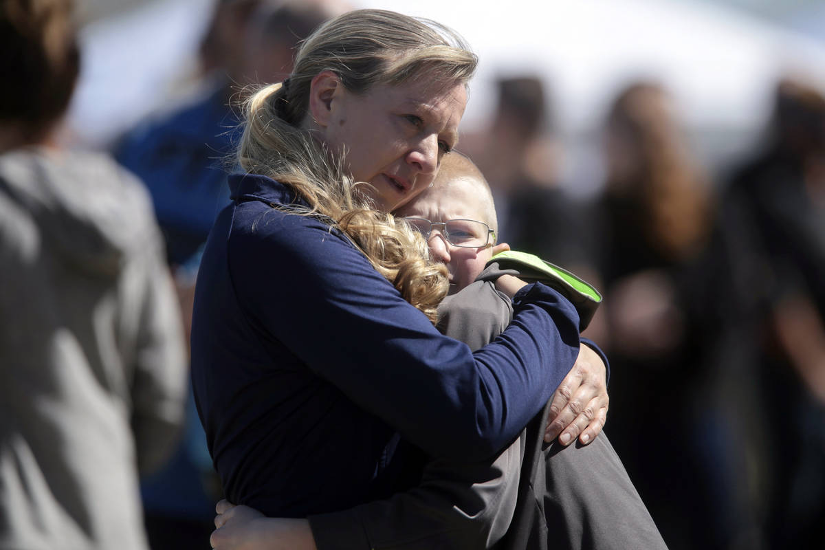 People embrace after a school shooting at Rigby Middle School in Rigby, Idaho, Thursday, May 6, ...