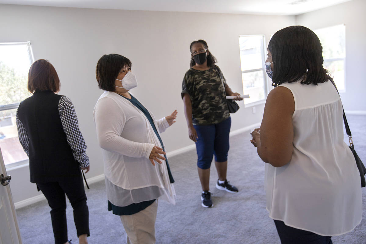 Yvonne Khoo, a realtor with eXp Realty, center left, shows a home to Coree McGinnis and Bonita ...