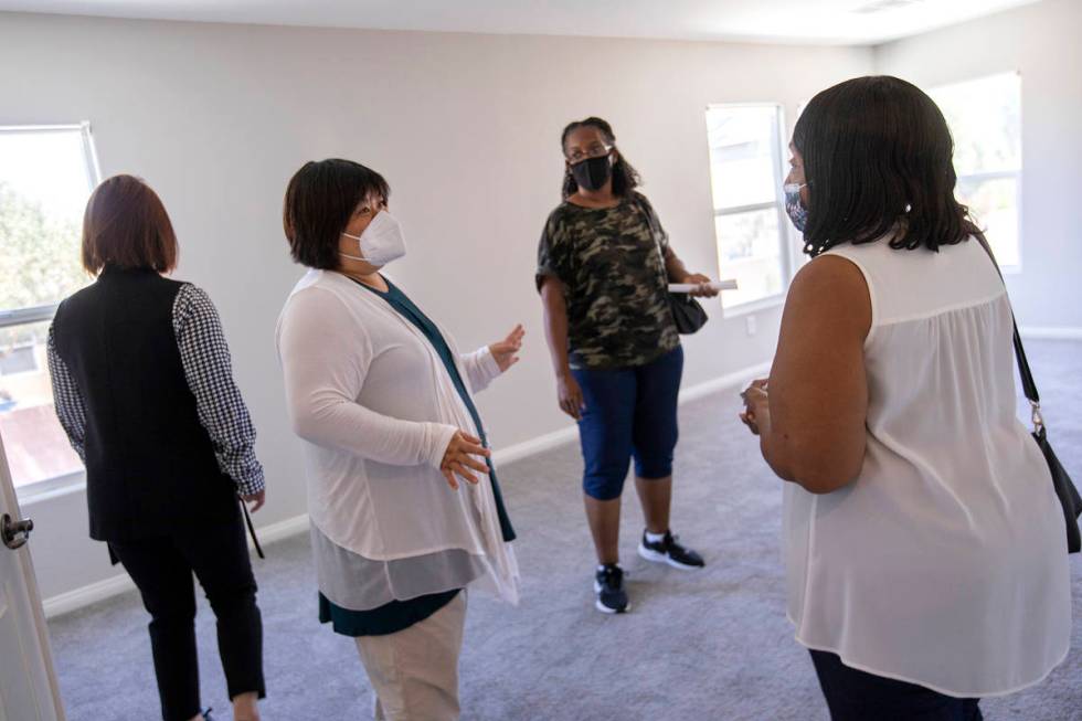 Yvonne Khoo, a realtor with eXp Realty, center left, shows a home to Coree McGinnis and Bonita ...
