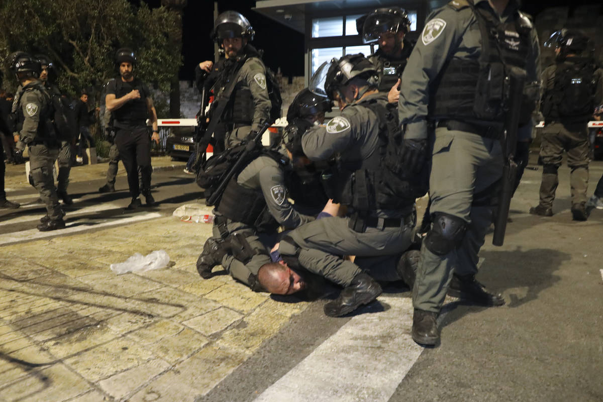 Israeli border police officers detain a Palestinian demonstrator during clashes with Palestinia ...