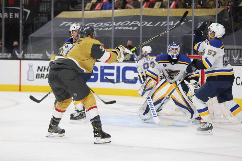 St. Louis Blues goaltender Ville Husso (35) looks on as his teammate left wing David Perron (57 ...