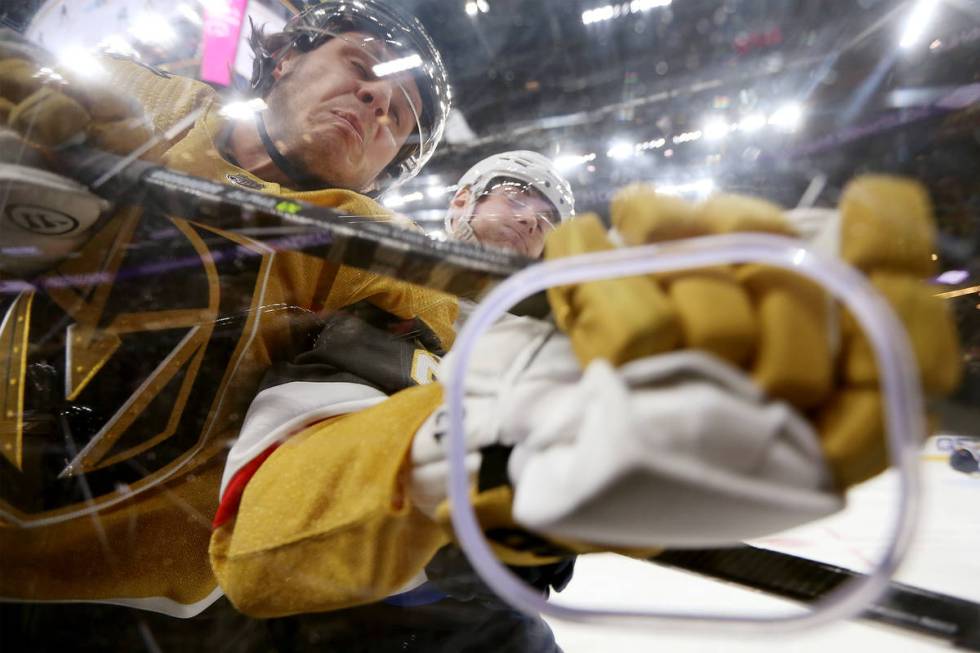 Vegas Golden Knights center Mattias Janmark (26) is slammed against the glass by St. Louis Blue ...